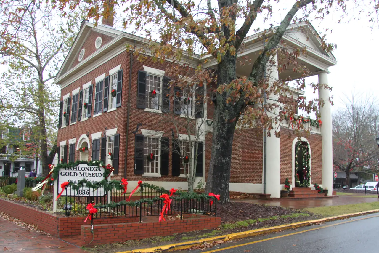 The red-brick Dahlonega Gold Museum decorated with evergreen garland, wreaths and big red bows.