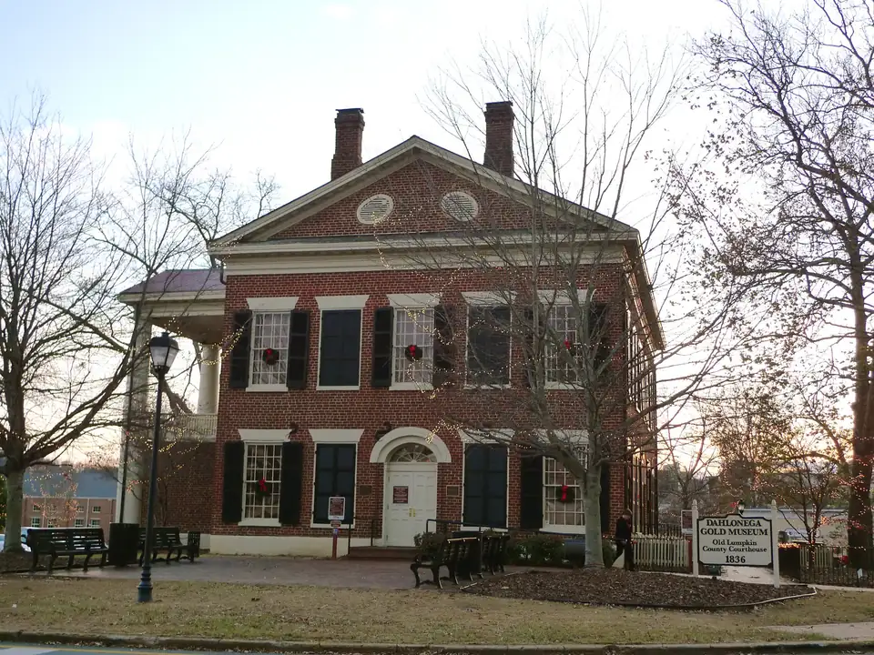 The old courthouse on the square at dusk, strung with holiday lights and wreaths in every window.