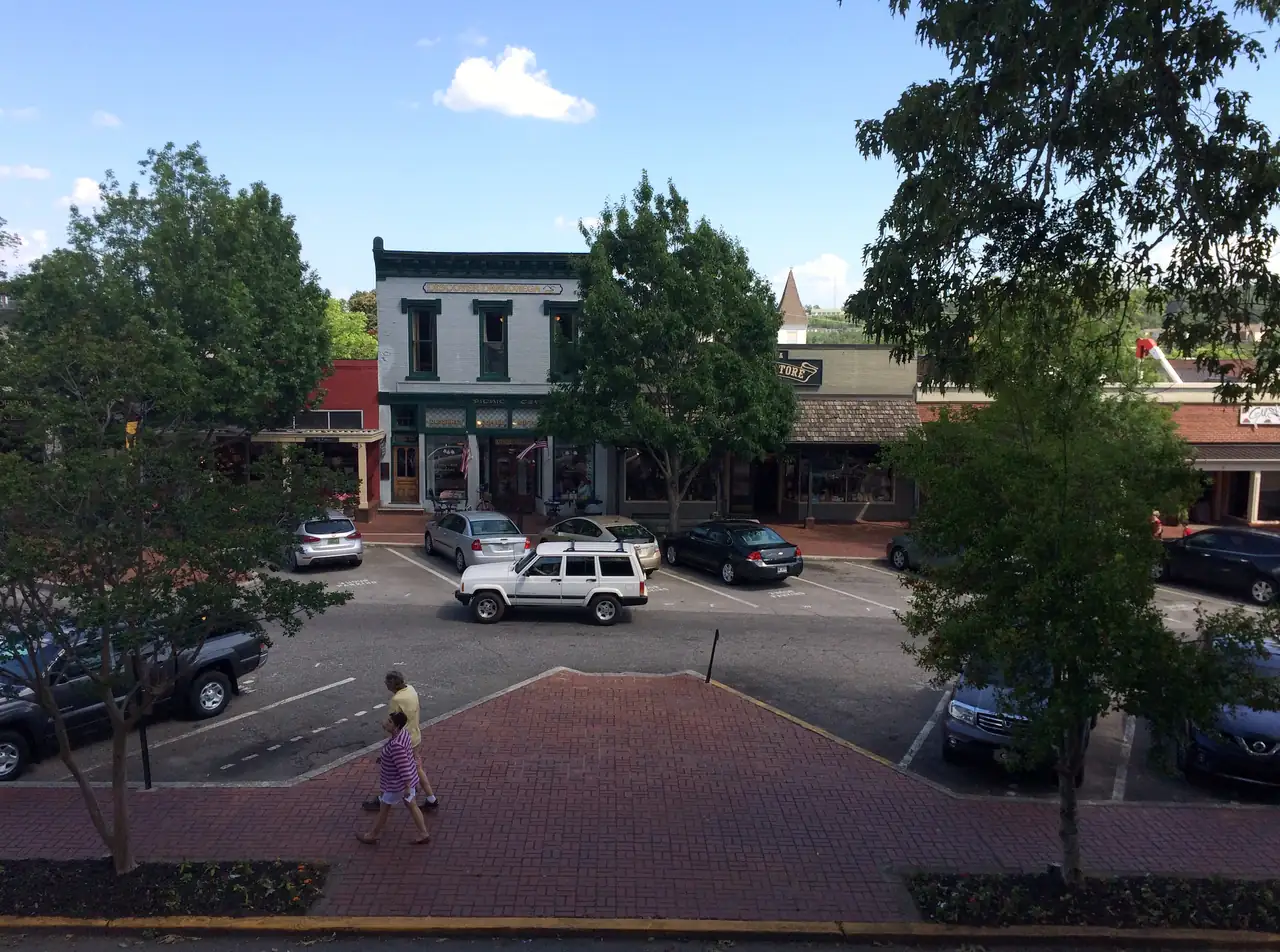 Storefronts on the Public Square seen from the old courthouse, with the Picnic Cafe and general store behind a row of parked cars.