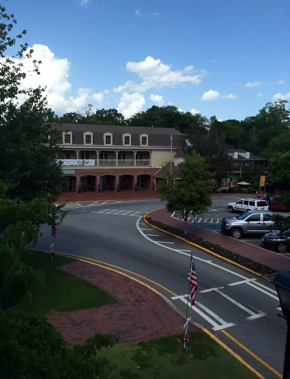The visitors center on the square, a two-story building with dormers and a long porch, seen from the old courthouse.